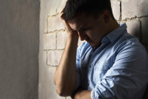 sad guy against wall